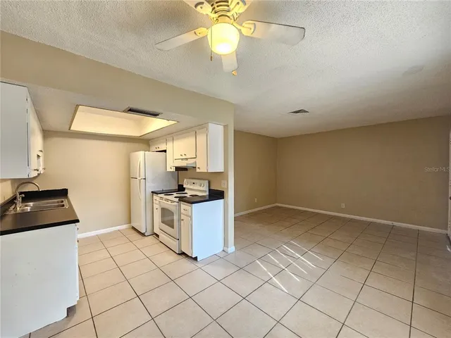 a kitchen with a sink a stove cabinets and counter space