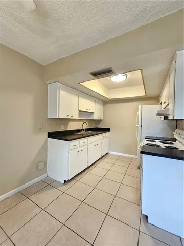 a kitchen with a sink a stove top oven and cabinets