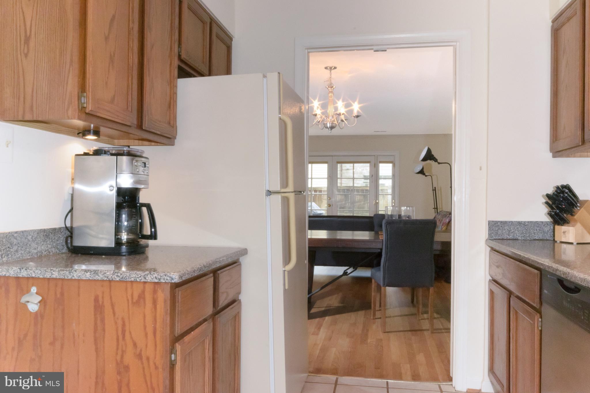428 West Glebe Road Alexandria, VA 22305 - Photo 5 of 25 a kitchen with stainless steel appliances granite countertop a refrigerator a stove and a sink with wooden floor
