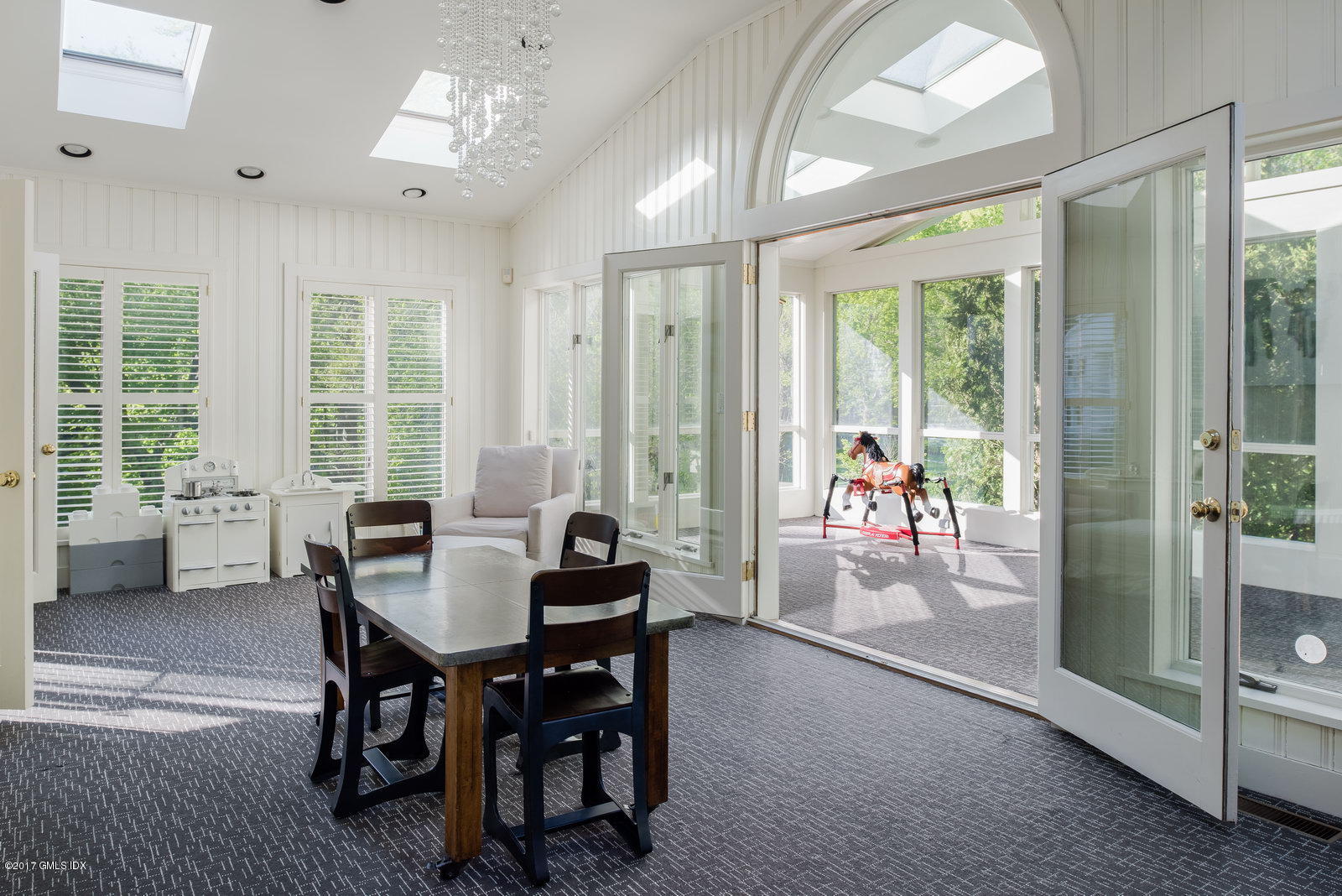 25 Windabout Drive Greenwich, CT 06831 - Photo 13 of 31 a view of a dining room and livingroom with furniture wooden floor and a chandelier