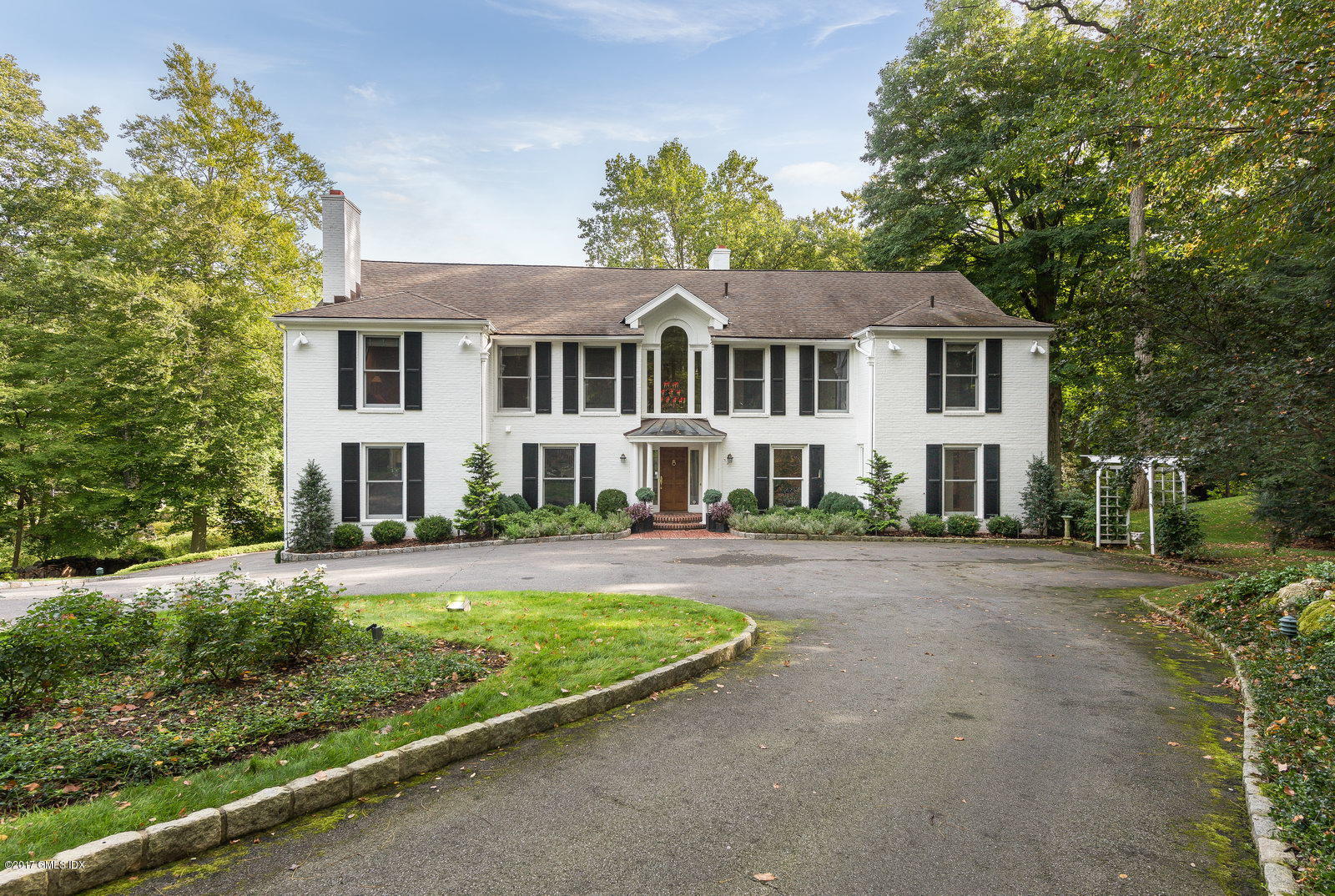 25 Windabout Drive Greenwich, CT 06831 - Photo 2 of 31 a front view of a house with a garden and trees