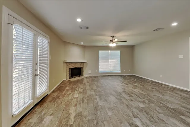 a view of an empty room with a fireplace and a window