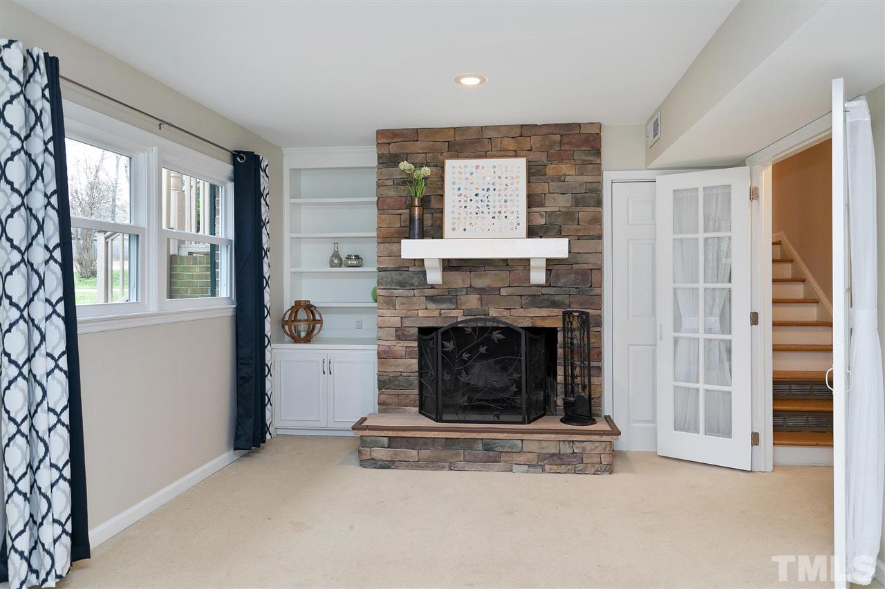 6509 Wrenwood Avenue Raleigh, NC 27607 - Photo 15 of 29 a living room with a fireplace and a large window