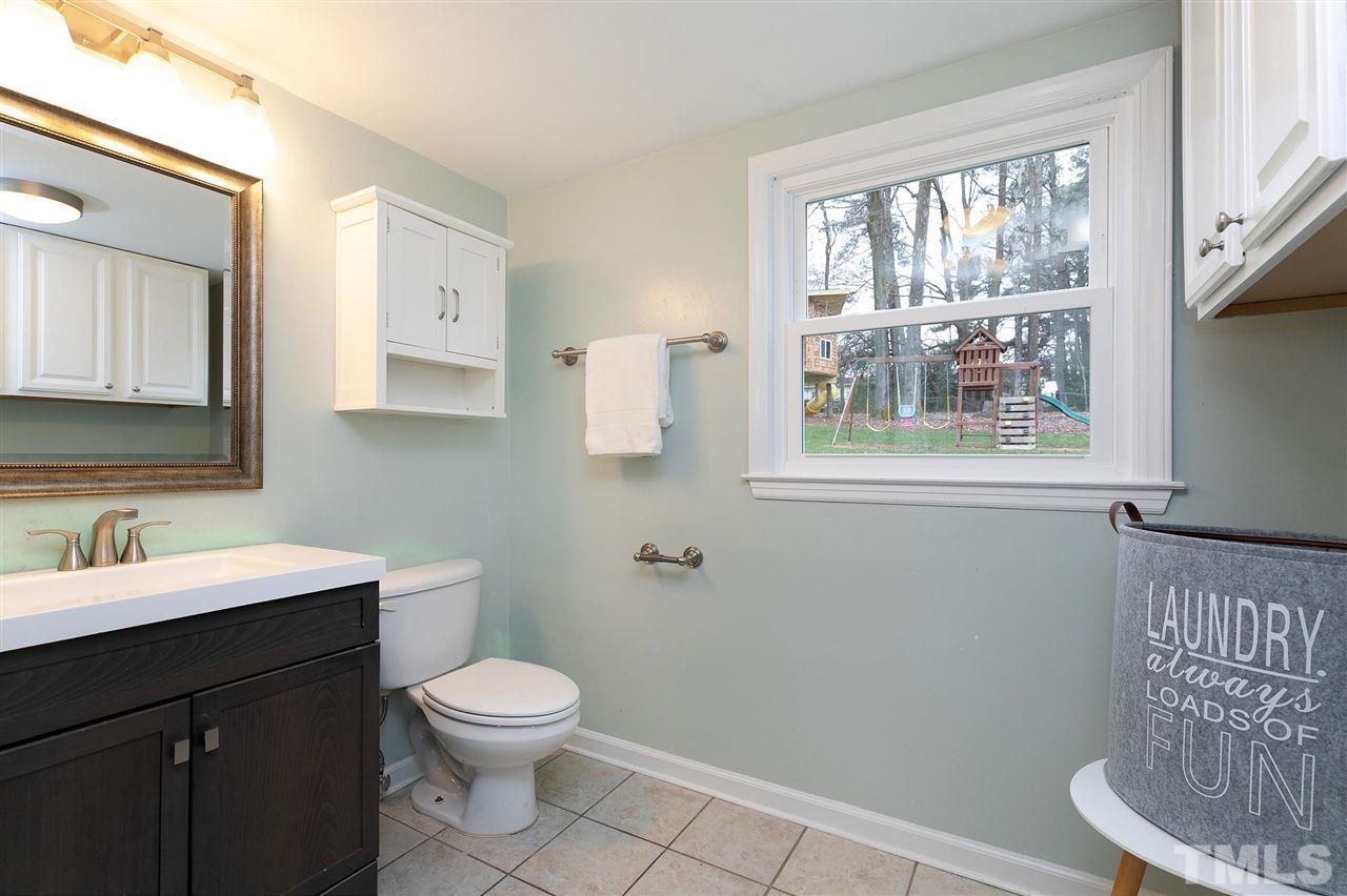 6509 Wrenwood Avenue Raleigh, NC 27607 - Photo 19 of 29 a bathroom with a toilet a sink a mirror and a window