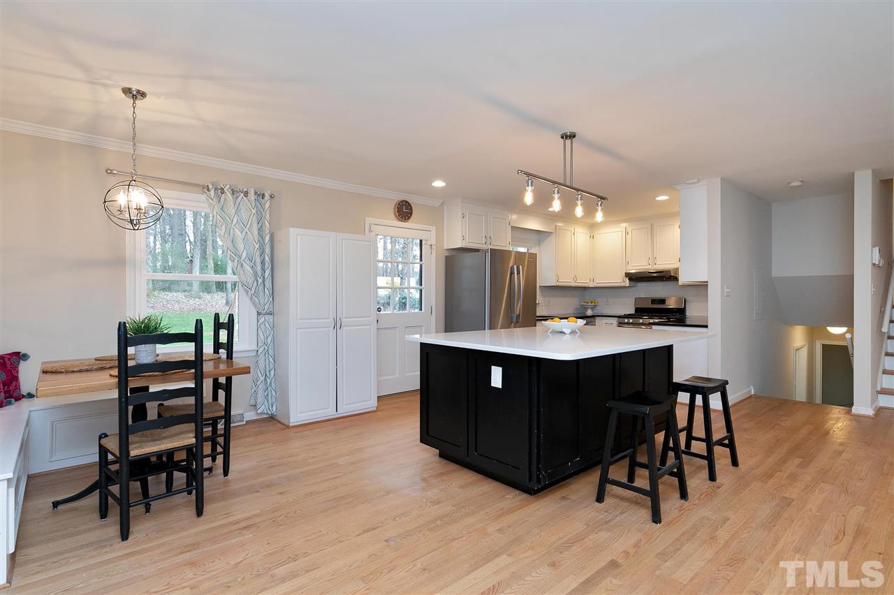 6509 Wrenwood Avenue Raleigh, NC 27607 - Photo 5 of 29 a kitchen with a sink chandelier and wooden floor
