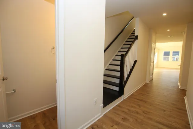 a view of a hallway with wooden floor and stairs