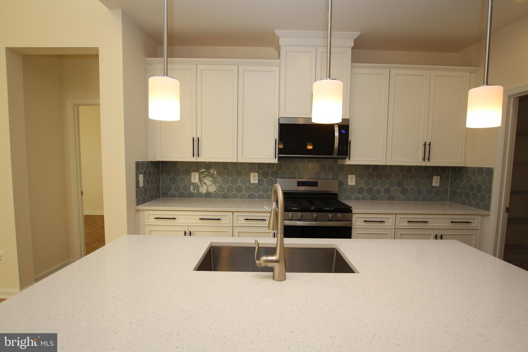390 Scranton Lane Ocean View, DE 19970 - Photo 4 of 14 a kitchen with stainless steel appliances a stove a sink a microwave a refrigerator and cabinets