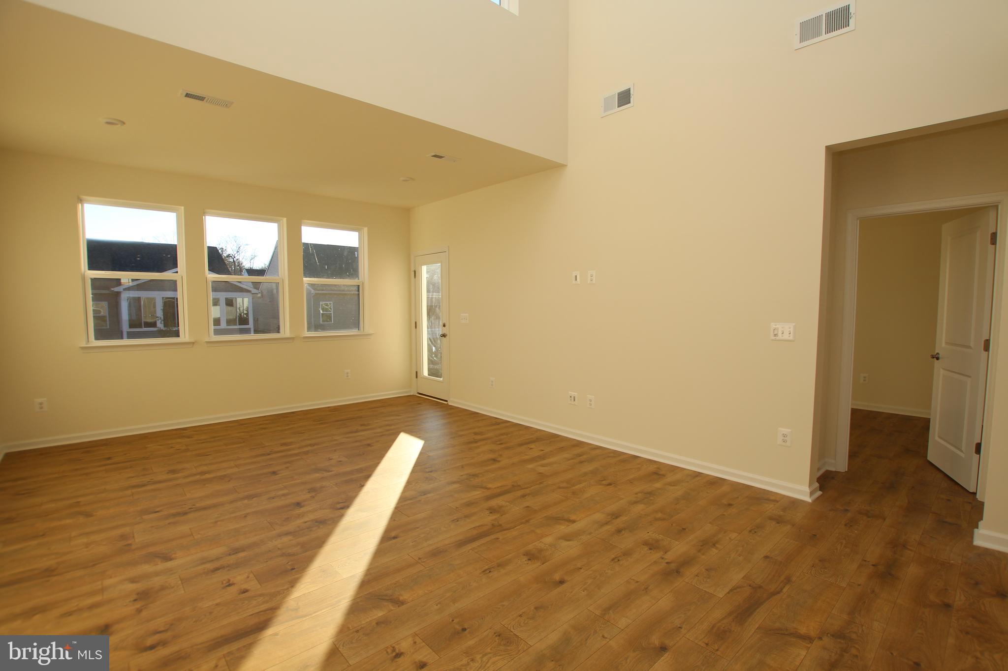 390 Scranton Lane Ocean View, DE 19970 - Photo 5 of 14 a view of an empty room with wooden floor and a window