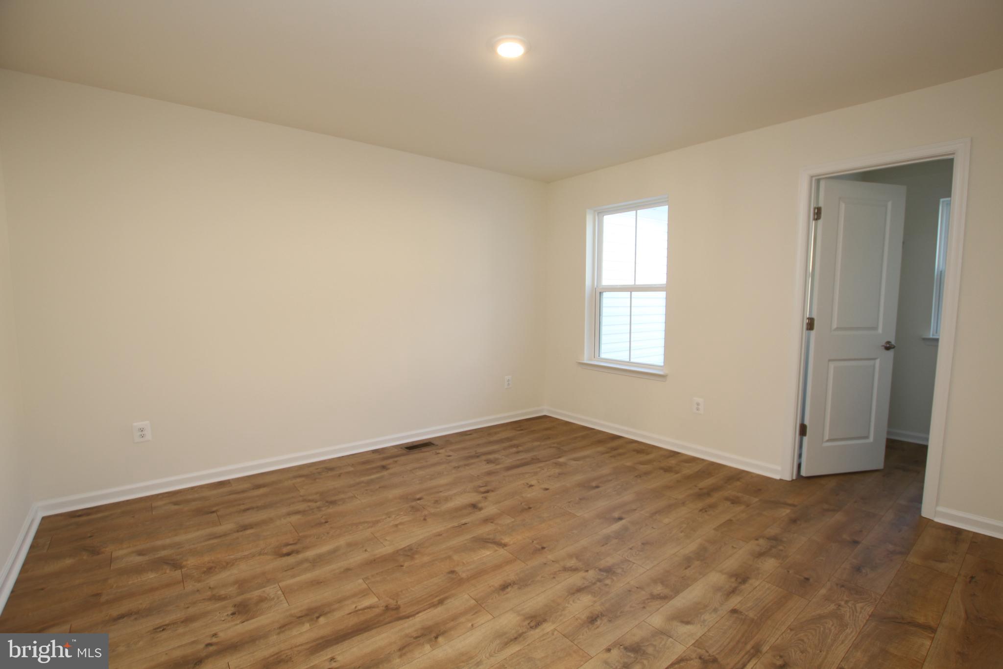 390 Scranton Lane Ocean View, DE 19970 - Photo 10 of 14 an empty room with wooden floor and windows