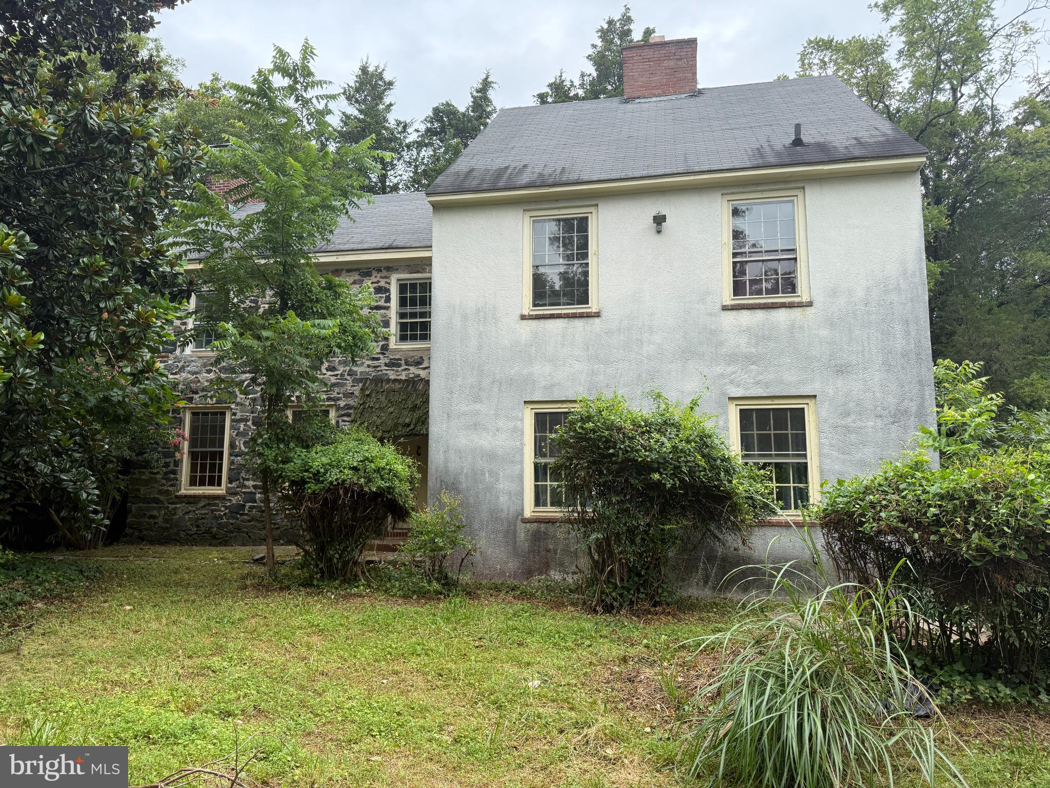 a front view of house with yard and trees in the background