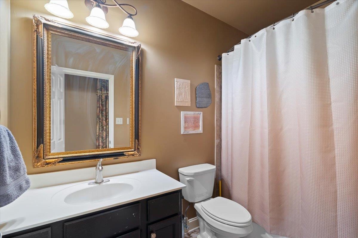 8485 Highway 196 Collierville, TN 38017 - Photo 13 of 34 a bathroom with a sink a toilet and shower curtain