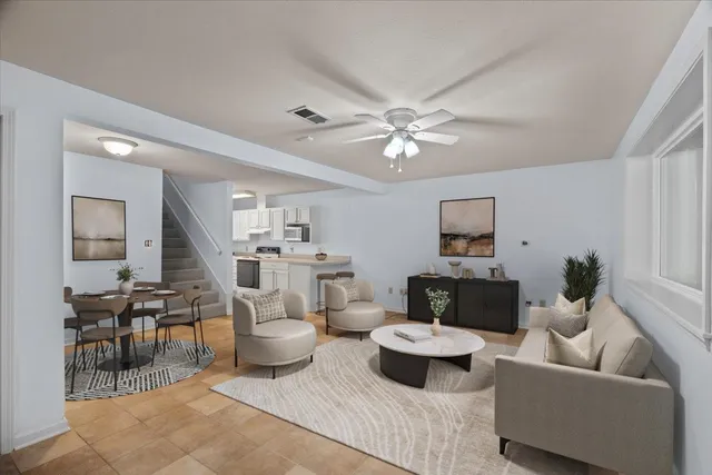 a living room with furniture and view of kitchen