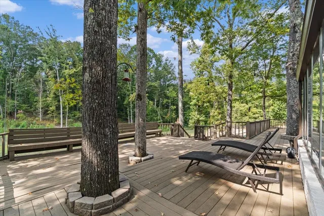 a view of a patio with table and chairs with wooden floor and fence