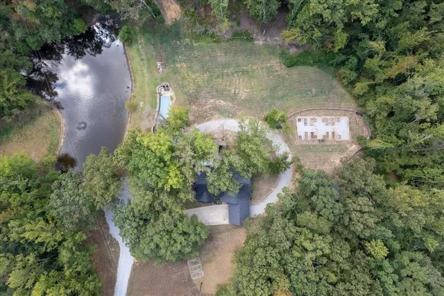 an aerial view of a house with a yard and large trees