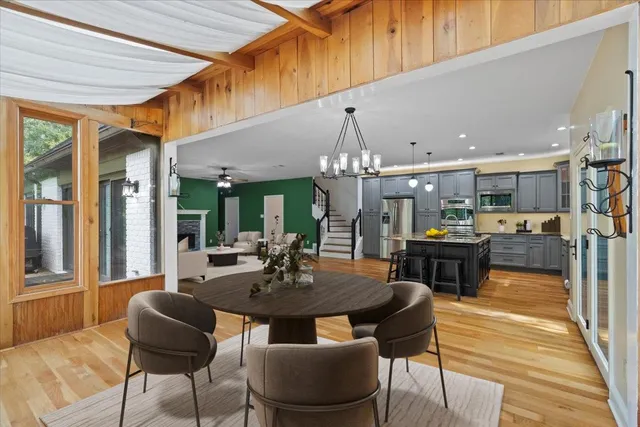 a view of a dining room and livingroom with furniture wooden floor a chandelier