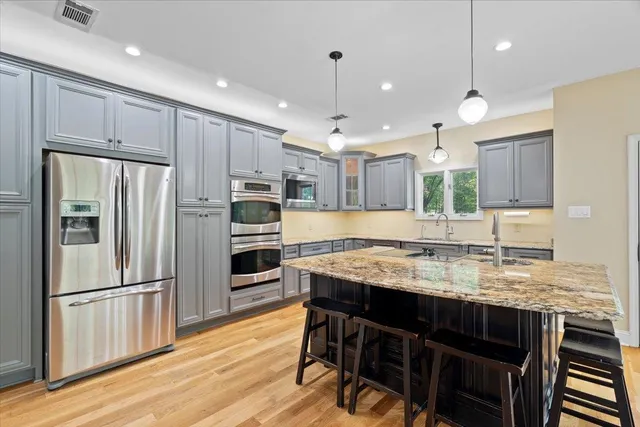 a kitchen with kitchen island white cabinets and stainless steel appliances