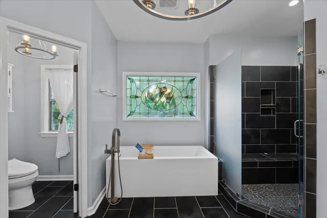 a spacious bathroom with a bathtub and toilet