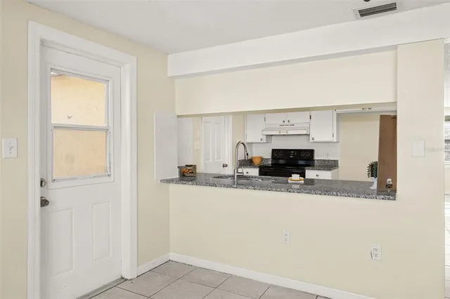 a kitchen with granite countertop a sink and a stove top oven