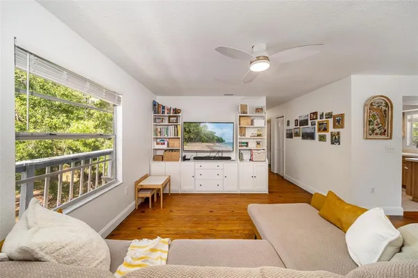 a large living room with stainless steel appliances kitchen island granite countertop furniture and a large window