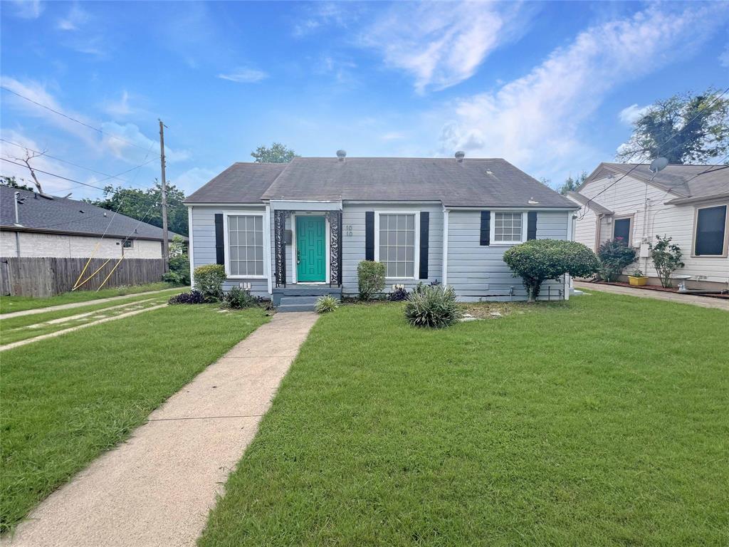 1010 Winters Street Dallas, TX 75216 - Photo 1 of 20 Light blue siding exterior featuring a vibrant turquoise entry door framed by decorative ironwork
