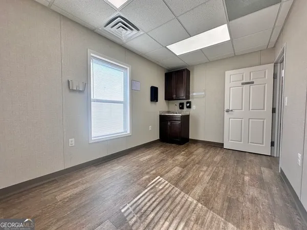 a view of empty room with kitchen and window