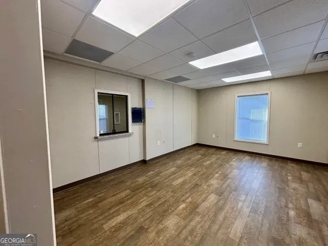 a view of an empty room with wooden floor and closet