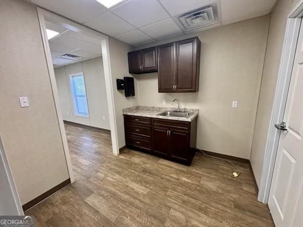a view of kitchen with stainless steel appliances granite countertop wooden cabinets and sink