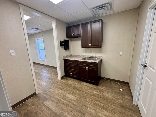 a view of kitchen with stainless steel appliances granite countertop wooden cabinets and sink