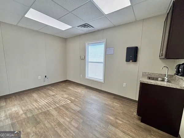 a view of a kitchen with wooden floor and a sink