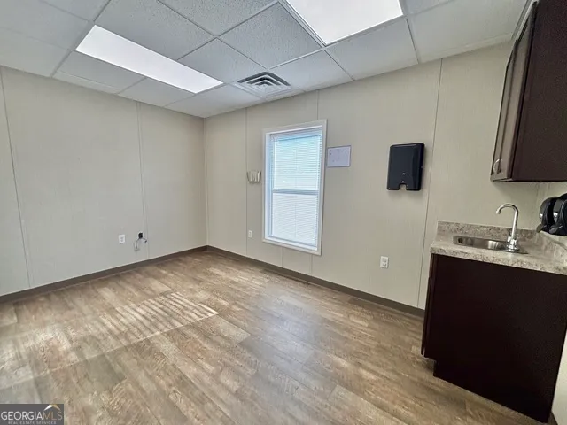 a view of a kitchen with wooden floor and a sink