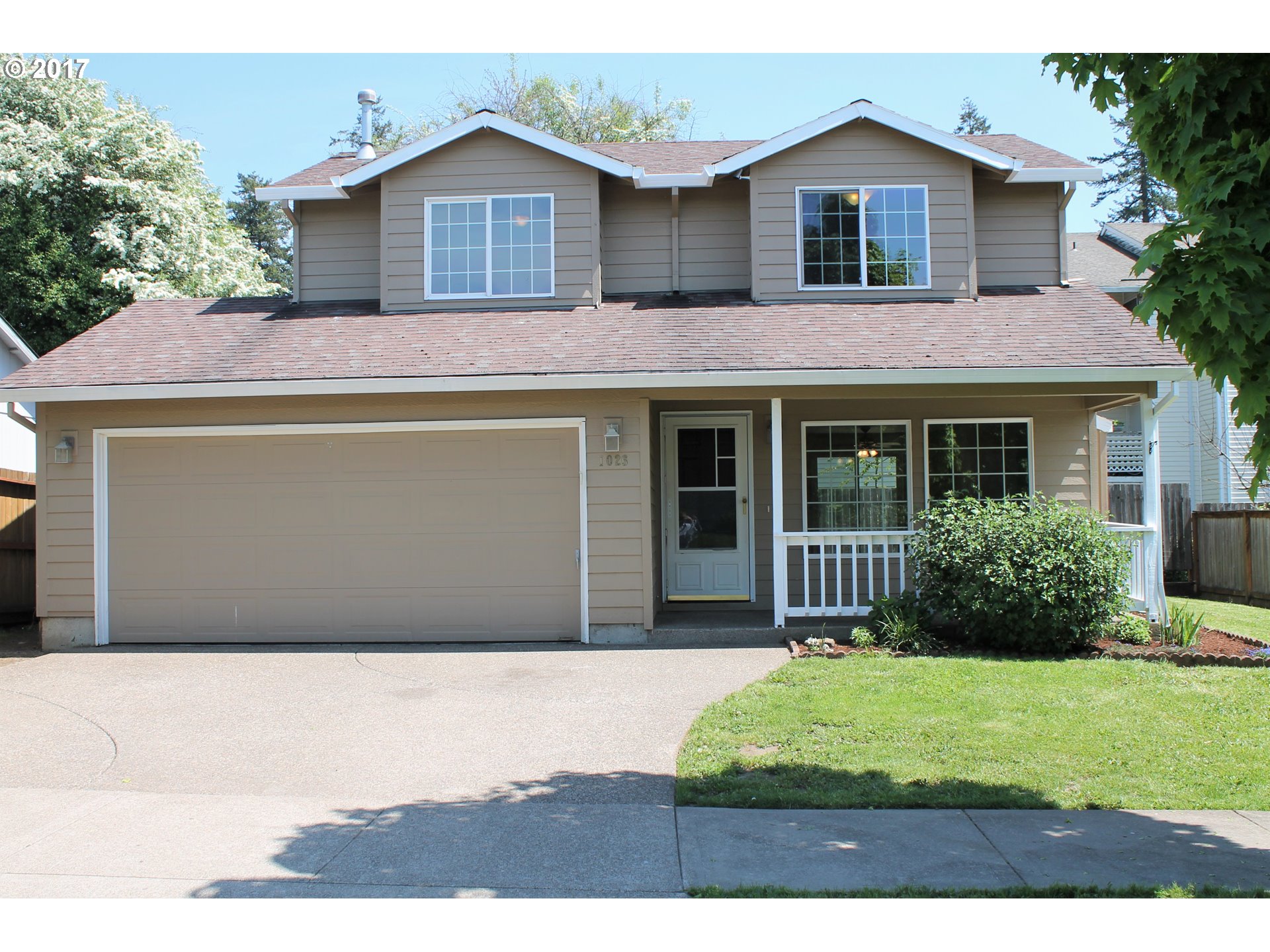 1026 Southwest Ivory Loop Gresham, OR 97080 - Photo 2 of 13 a front view of a house with a garden
