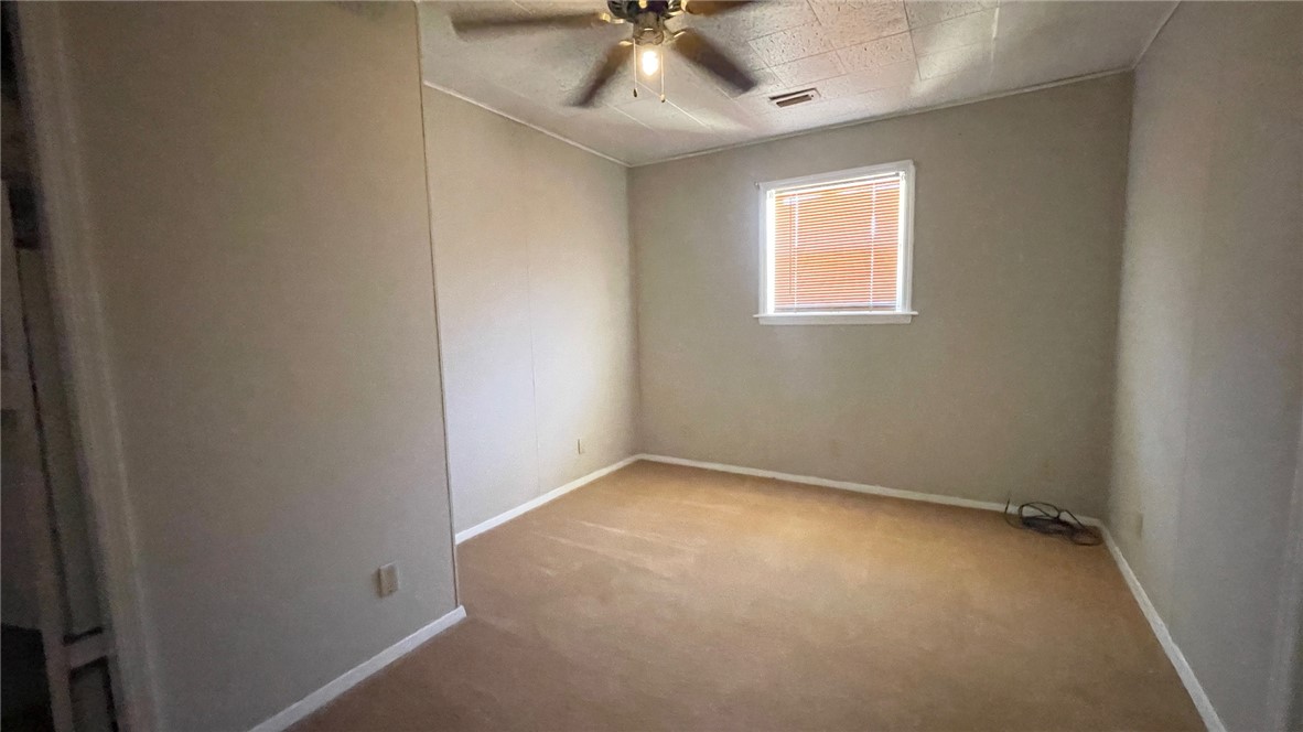 10933 Clyde Acord Road Franklin, TX 77856 - Photo 7 of 20 an empty room with a window and a fan