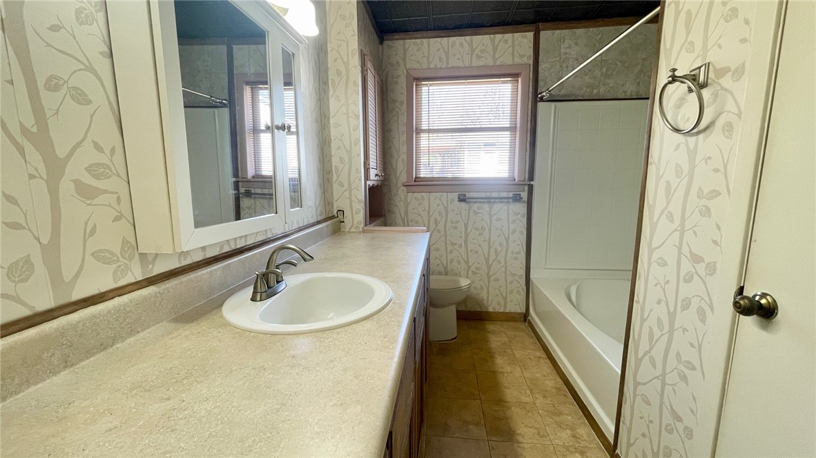 10933 Clyde Acord Road Franklin, TX 77856 - Photo 9 of 20 a bathroom with a granite countertop sink a mirror and a shower