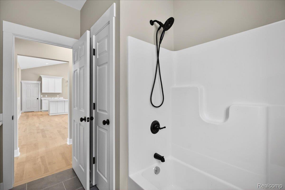 4050 Metamora Ridge Road Metamora, MI 48455 - Photo 51 of 65 Bathroom featuring shower / bath combination and dark tile patterned flooring