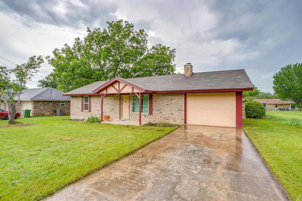 709 North Ave B Springtown, TX 76082 - Photo 4 of 32 a front view of a house with a garden and deck