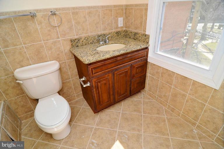 514 Park Road Northwest Washington, DC 20010 - Photo 11 of 15 a bathroom with a granite countertop toilet a sink and a shower