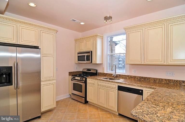 514 Park Road Northwest Washington, DC 20010 - Photo 12 of 15 a kitchen with white cabinets and stainless steel appliances