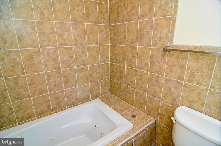 514 Park Road Northwest Washington, DC 20010 - Photo 5 of 15 a bath tub sitting next to a white toilet and a shower