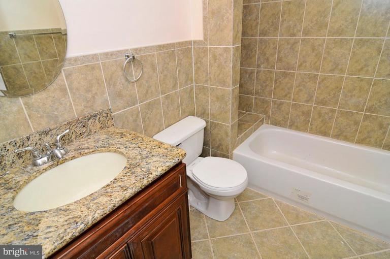 514 Park Road Northwest Washington, DC 20010 - Photo 10 of 15 a bathroom with a granite countertop sink a toilet and bathtub