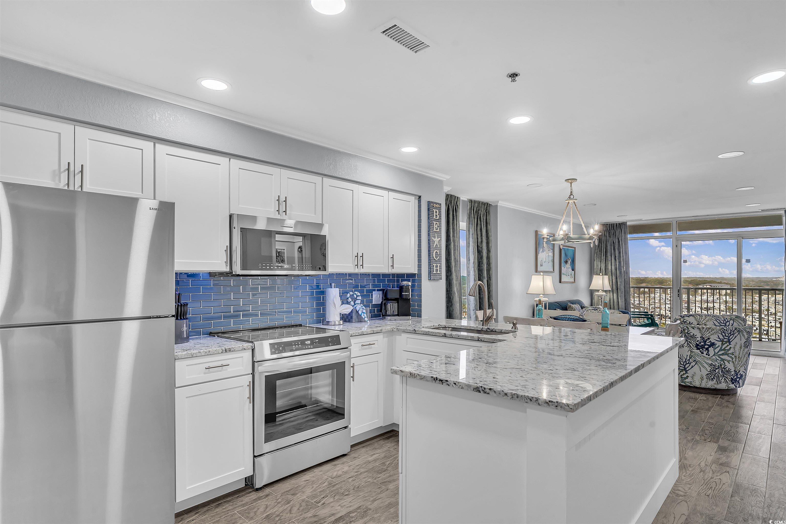 161 Seawatch Drive, Unit 1118 Myrtle Beach, SC 29572 - Photo 2 of 40 Kitchen featuring appliances with stainless steel finishes, white cabinetry, decorative backsplash, light stone counters, and ornamental molding
