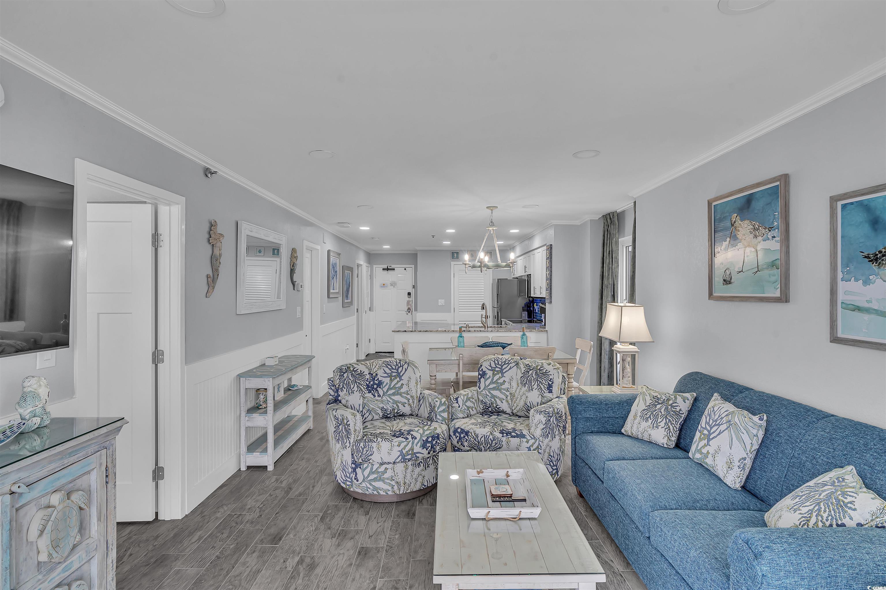 161 Seawatch Drive, Unit 1118 Myrtle Beach, SC 29572 - Photo 8 of 40 Living room with ornamental molding, a wainscoted wall, a chandelier, wood finish floors, and recessed lighting