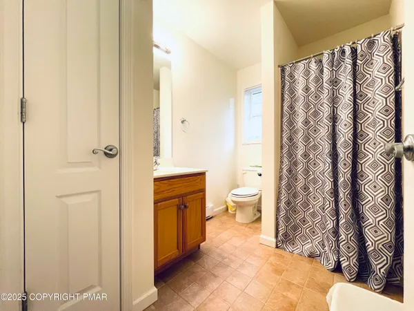 a bathroom with a toilet and a shower curtain