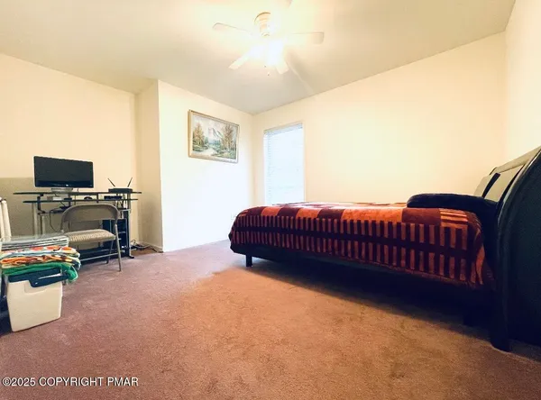 a bedroom with a bed a flat screen tv and dresser