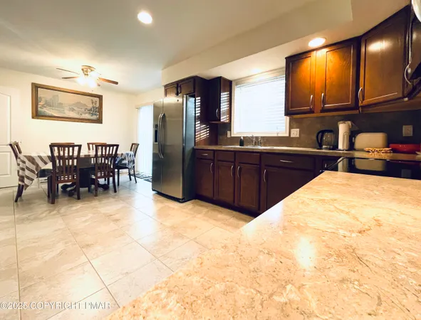 a kitchen with stainless steel appliances wooden cabinets a dining table and chairs