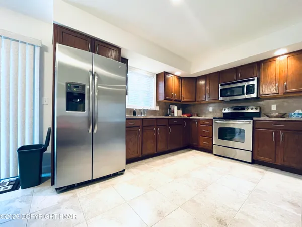 a kitchen with stainless steel appliances granite countertop a stove top oven a sink and dishwasher