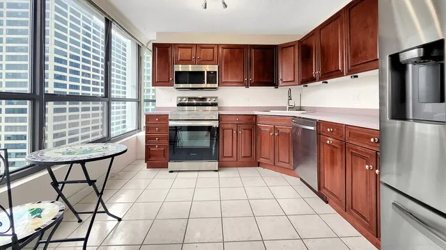 a kitchen with a refrigerator a stove a sink and cabinets