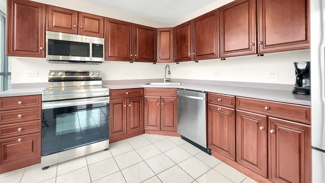 a kitchen with stainless steel appliances kitchen island granite countertop a stove a sink and a microwave