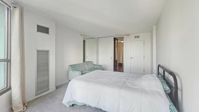 a bathroom with a granite countertop toilet sink and mirror