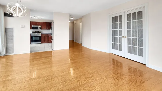 a view of empty room with wooden floor and fan
