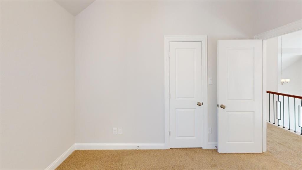 8407 Cornerstone Drive Rowlett, TX 75088 - Photo 14 of 25 Open doorway with crisp white trim, providing access to a carpeted upper level featuring a wrought iron and wood railing